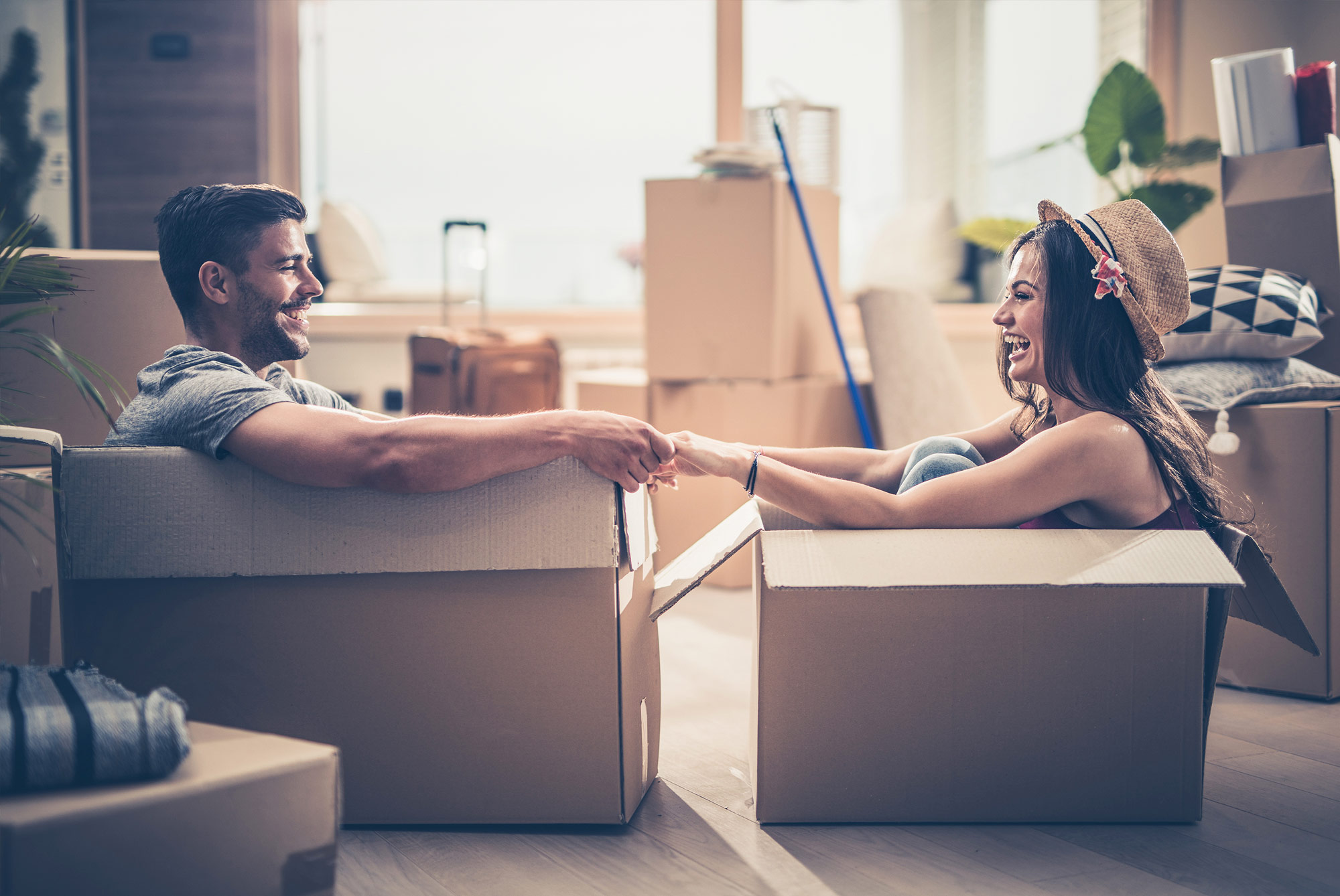 Young couple having fun in moving boxes.