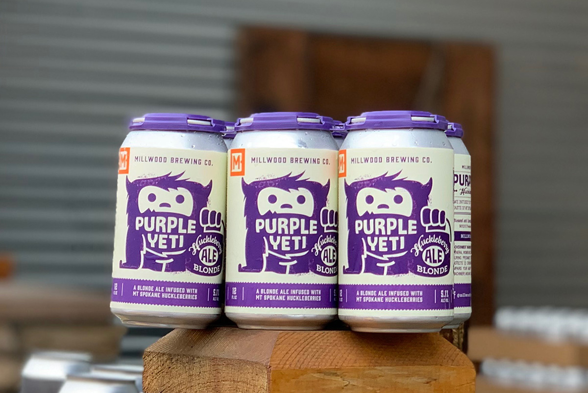 A 6-pack of 12oz. Purple Yeti Huckleberry Blonde Ale cans. Craft beer label designs.